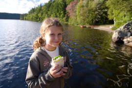 Girl eating by lake